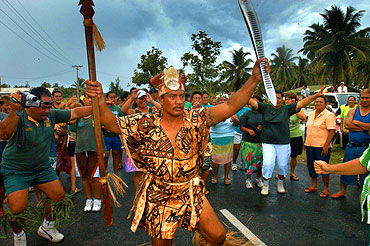 Dressed in traditional dress, Toa Isamaela, one of the 1800 people on the island to hold the baton, dances with glee.