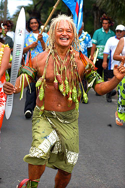 Pa, known as "the son of Polynesia" and wearing the strand of Kopi (bulbs of the bird of paradise plant) around his neck, dances with joy as the baton arrives.