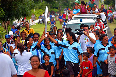 The Aitutaki mixed soccer team carries the Queen's Baton during a tour of the local islands.